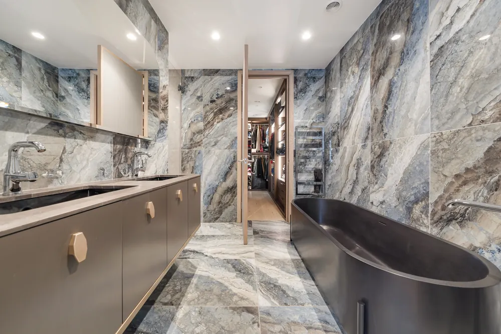 Marble bathroom with a dark freestanding bath